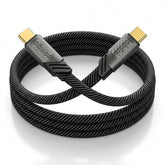 A coiled black braided HDMI cable with gold-toned USB-C connectors, featuring visible branding on the connector housings, set against a clean white background.