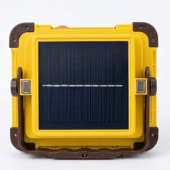 A rugged yellow and brown portable solar lantern or power bank with a large dark blue solar panel on the front, shown against a plain white background.