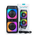 A pair of wireless karaoke speakers with RGB rainbow lighting, shown alongside their retail packaging box, a handheld microphone, and a car adapter cable on a white background.